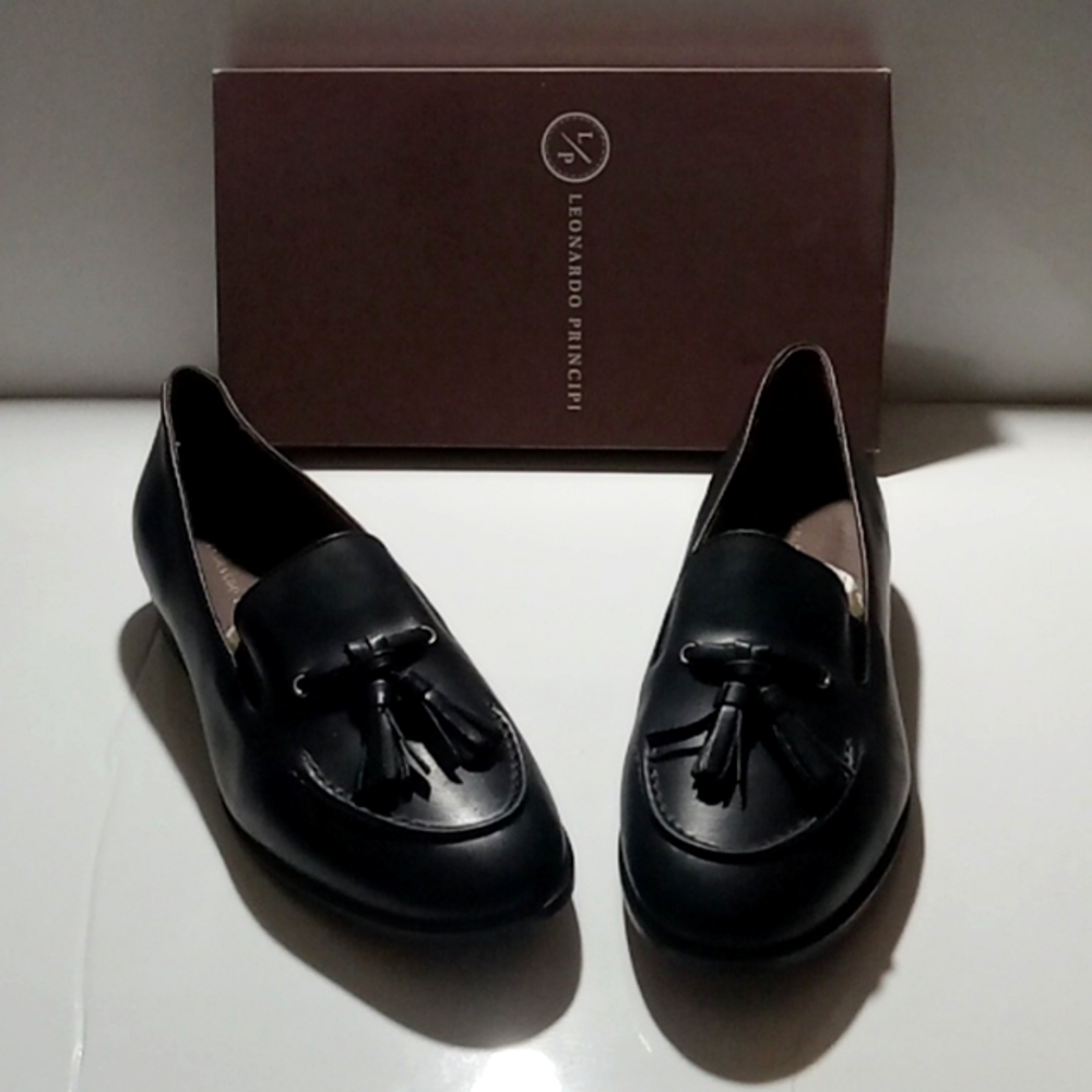 Women's classic handmade black leather loafers with black tassels.